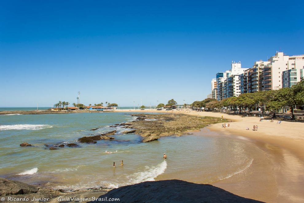 Imagem de quatro pessoas próximo as pedra na Praia Castanheiras em Guarapari.